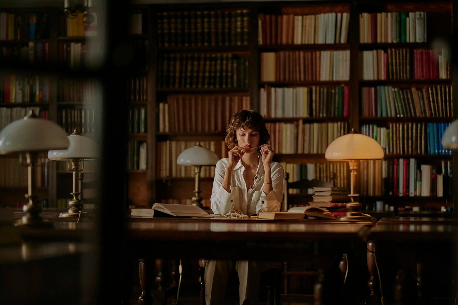 kobieta w bibliotece patrząca na złotą biżuterię BELLER